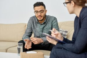 a man discusses an alcohol addiction treatment program with a therapist