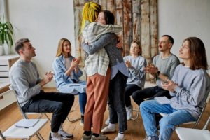 two people hug amongst a group in an opiate detox center