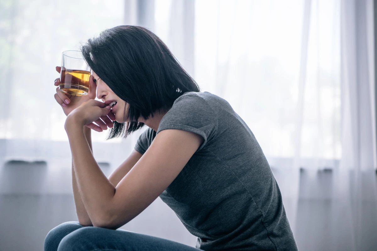 What are the 4 C's of addiction? - unhappy female with an alcoholic drink